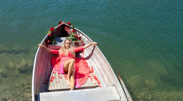 romantic scene with female model with long blond hair on a boat. Life style Shooting of a girl