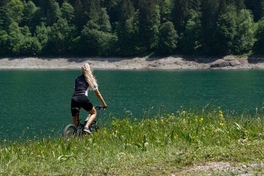 Life style woman with long blond hair on mountain bike in Swiss