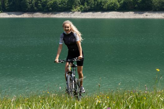 Life style woman with long blond hair on mountain bike in Swiss Alps