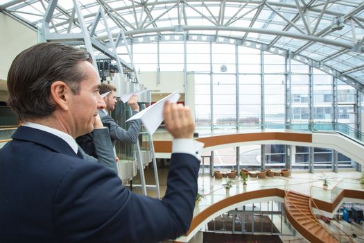 Team of business people throwing together paper planes in modern office building