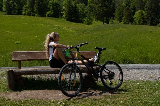 Life style woman with long blond hair on mountain bike in Swiss Alps