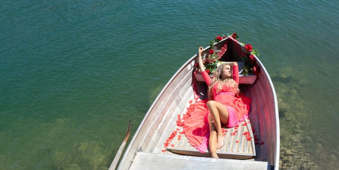 woman with long blond hair on boat with roses and flowers on blue