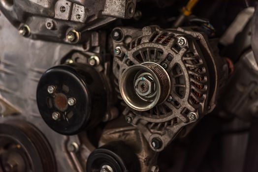 Disassembled car dirty engine close-up to engine parts and dynamo genarator charger at car garage