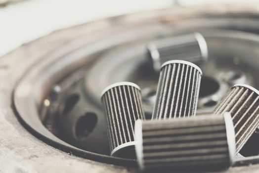 Old lubricant engine oil filter at car garage after changing the new oil filter for repair or maintenance in a car engine