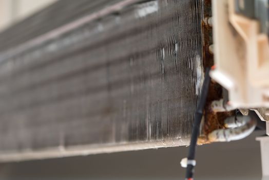 Worker to cleaning coil cooler of air conditioner by water for clean a dust on the wall in customer home when maintenance service