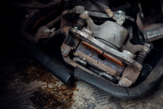 Car mechanic or serviceman checking a disc brake and asbestos brake pads it's a part of car use for stop the car for safety at front wheel this a used old part for change at car garage