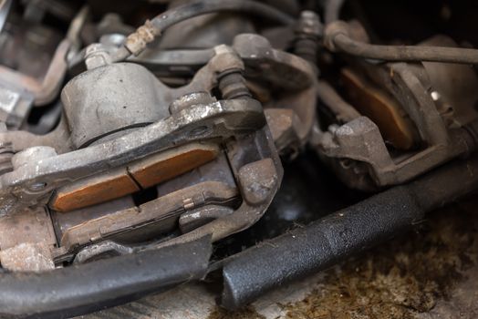 Car mechanic or serviceman checking a disc brake and asbestos brake pads it's a part of car use for stop the car for safety at front wheel this a used old part for change at car garage