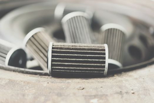 Old lubricant engine oil filter at car garage after changing the new oil filter for repair or maintenance in a car engine