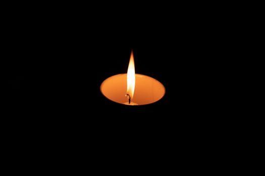 Lit candle in a cup after load-shedding