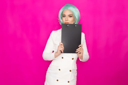 Beautiful young woman with short blue hair in a white business dress jacket holding a black folder with documents