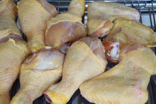 Processcooking chicken legs and chicken breast on a barbecue grill outdoors. Picnic, eating outdoors. Metal barbecue grill brazier .
