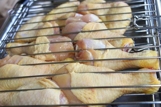 Processcooking chicken legs and chicken breast on a barbecue grill outdoors. Picnic, eating outdoors. Metal barbecue grill brazier .