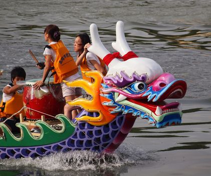 KAOHSIUNG, TAIWAN - JUNE 23: An unidentified team competes in the 2012 Dragon Boat Races on the Love River on June 23, 2012 in Kaohsiung