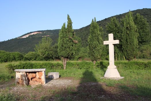 Withe marble cross against blue cloudy sky in Italy