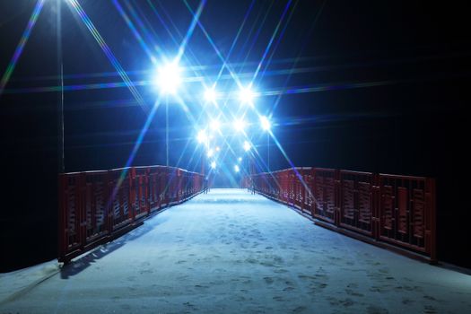 Night landscape with nice red bridge across river in winter at night