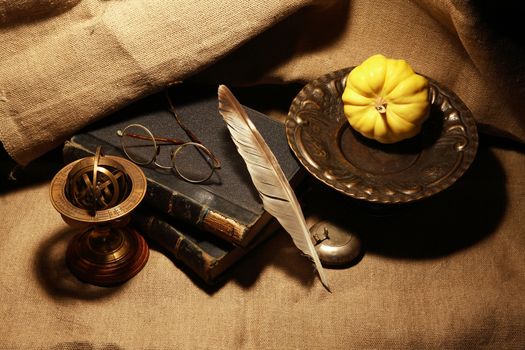 Vintage still life with old books and quill pen on canvas background