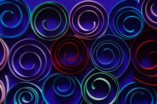 Multicolored spirals made from paper on blue background