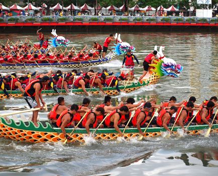 KAOHSIUNG, TAIWAN - JUNE 23: Four unidentified teams compete in the 2012 Dragon Boat Races on the Love River on June 23, 2012 in Kaohsiung