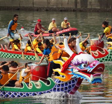 KAOHSIUNG, TAIWAN - JUNE 23: Two unidentified teams of female athletes compete in the 2012 Dragon Boat Races on the Love River on June 23, 2012 in Kaohsiung