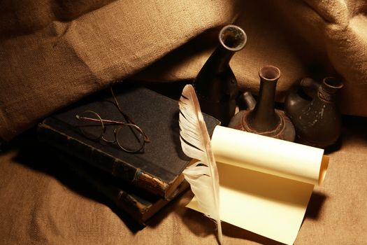 Vintage still life with old books and quill pen on canvas background