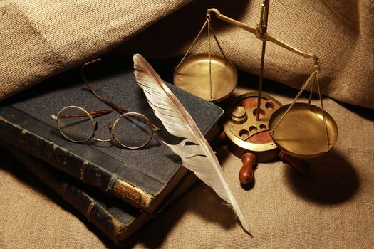 Vintage still life with old books and quill pen on canvas background