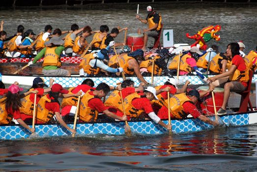 KAOHSIUNG, TAIWAN - JUNE 11: Three unidentified teams compete in the 2013 Dragon Boat Races on the Love River on June 11, 2013 in Kaohsiung