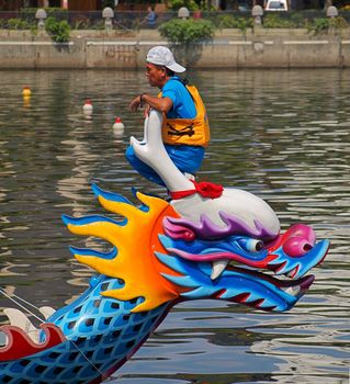 KAOHSIUNG, TAIWAN - JUNE 7:  An unidentified coach trains his team for the upcoming 2013 Dragon Boat Festival on the Love River on June 7, 2013 in Kaohsiung .