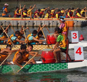 KAOHSIUNG, TAIWAN - JUNE 11: Three unidentified teams compete in the 2013 Dragon Boat Races on the Love River on June 11, 2013 in Kaohsiung