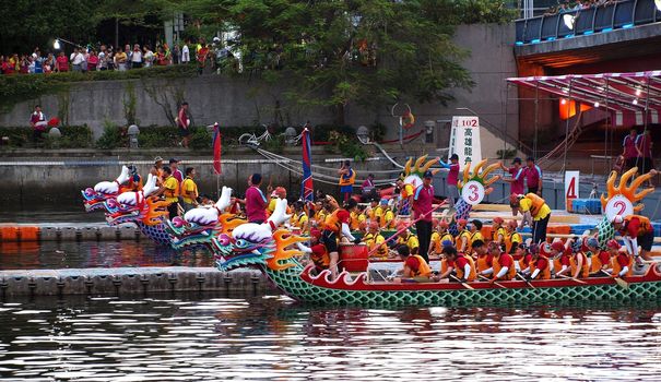 KAOHSIUNG, TAIWAN - JUNE 11: Four unidentified teams compete in the 2013 Dragon Boat Races on the Love River on June 11, 2013 in Kaohsiung