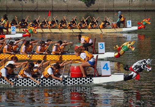 KAOHSIUNG, TAIWAN - JUNE 11: Four unidentified teams compete in the 2013 Dragon Boat Races on the Love River on June 11, 2013 in Kaohsiung