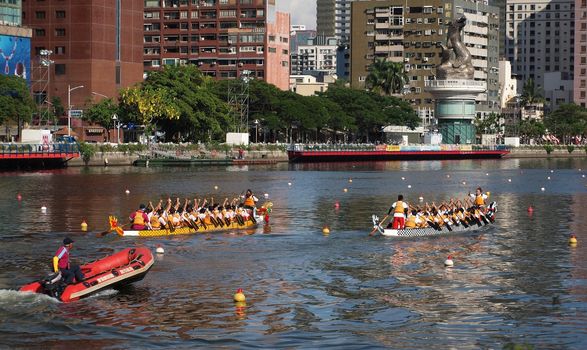 KAOHSIUNG, TAIWAN - JUNE 11: A lifeboat follows two unidentified teams who compete in the 2013 Dragon Boat Races on the Love River on June 11, 2013 in Kaohsiung