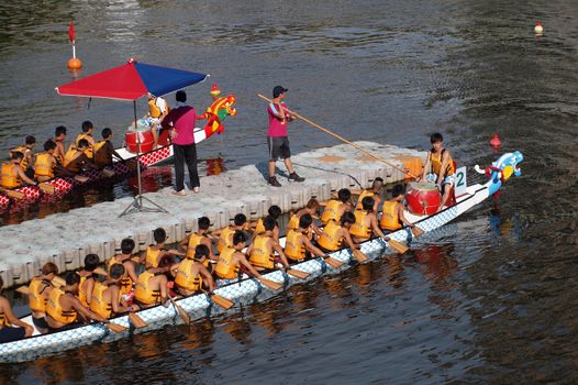KAOHSIUNG, TAIWAN - JUNE 11: Two unidentified teams prepare to compete in the 2013 Dragon Boat Races on the Love River on June 11, 2013 in Kaohsiung