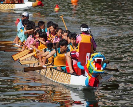 KAOHSIUNG, TAIWAN - JUNE 11: The Fushan High School  team competes in the 2013 Dragon Boat Races on the Love River on June 11, 2013 in Kaohsiung