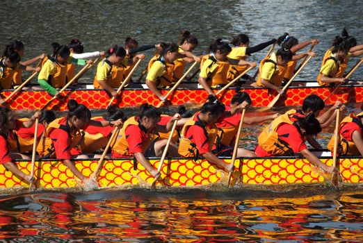KAOHSIUNG, TAIWAN - JUNE 11: Two unidentified female teams compete in the 2013 Dragon Boat Races on the Love River on June 11, 2013 in Kaohsiung