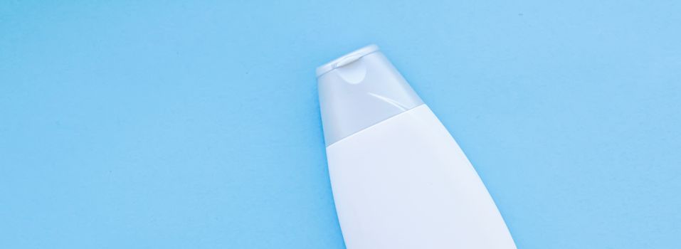Blank label cosmetic container bottle as product mockup on blue background, hygiene and healthcare