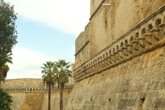 Bari, Puglia, Italy. Walls of the Norman Swabian castle of Bari. The gardens with green plants and the fort built by Frederick II.
