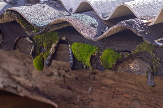 Old wooden plank beam fragment on slate wall background close-up, selective focus.