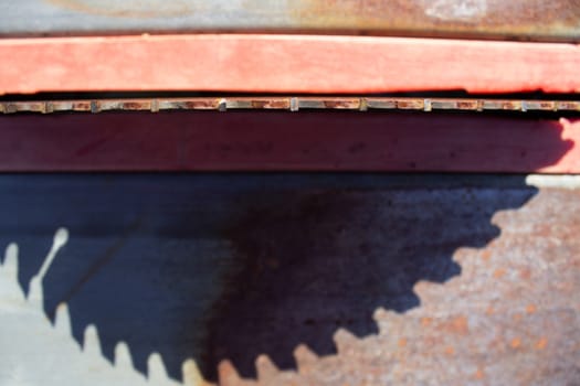 Round saw with teeth in the machine and its shadow.