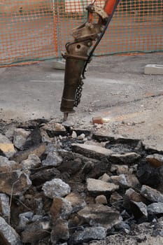 Road construction site. Demolition of the asphalt of a road with a jackhammer.