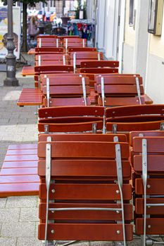 cafe street tables with chairs empty waiting for visitors arranges in structure red.