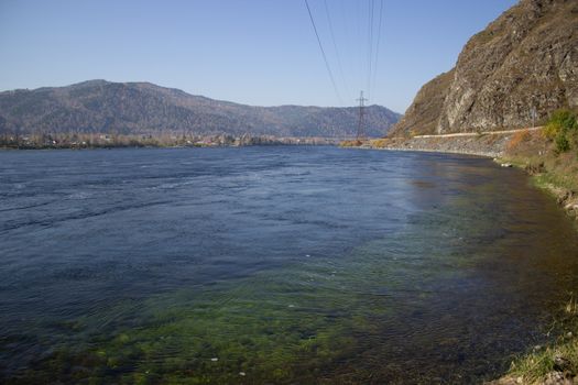 The mountains and the shore near the large mountain river.