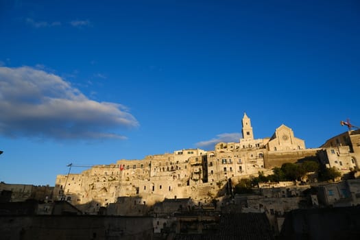 Houses, church and bell tower in the city of Matera in Italy. The tuff blocks are the material used for the construction of the houses.