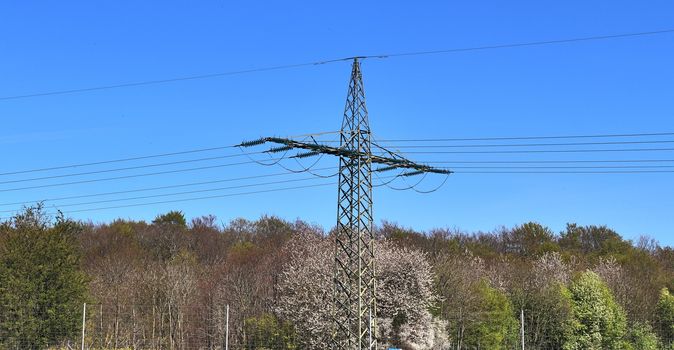 Close up view on a big power pylon transporting electricity in a countryside area in Europe