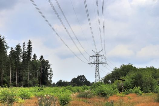 Close up view on a big power pylon transporting electricity in a countryside area in Europe