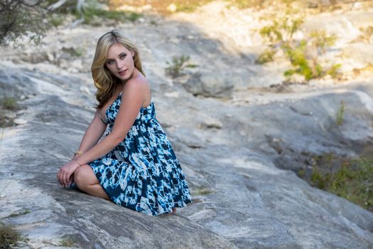 A gorgeous blonde model enjoys a summers day outdoors in a park