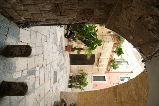 Bari, Puglia, Italy. About 11/2019.  Ancient houses in the alleys of the city of Bari. Ogival vault in an alley. Marble flooring.