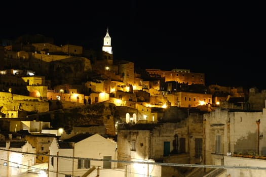 Night illumination of the ancient city of Matera. Houses made of blocks of tufa stone.