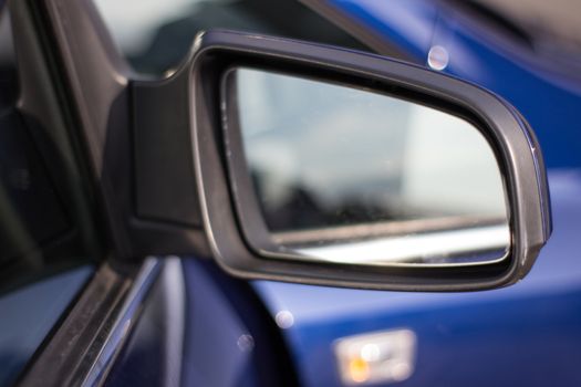 Landscape in the sideview mirror of a speeding car