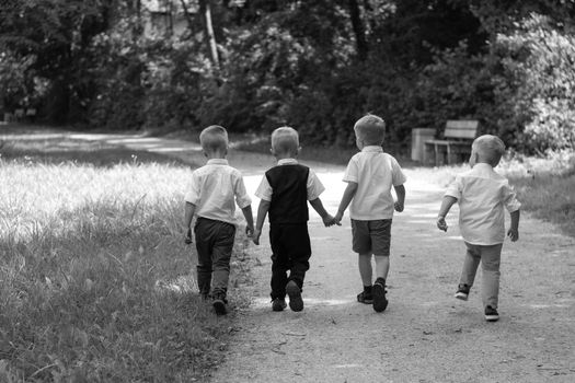 Group Of Children Running Along Path Towards Camera In Park