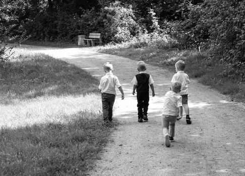 Group Of Children Running Along Path Towards In Park